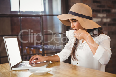 A businesswoman using her laptop while enjoying a coffee