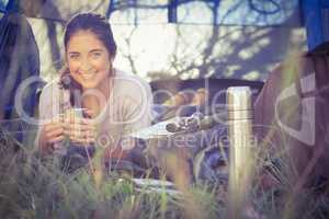 Smiling brunette camper lying in tent