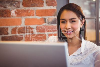 Businesswoman having coffee and working on laptop