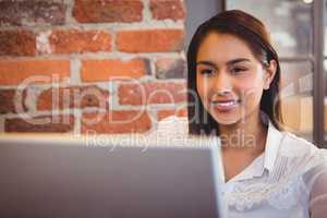 Businesswoman having coffee and working on laptop