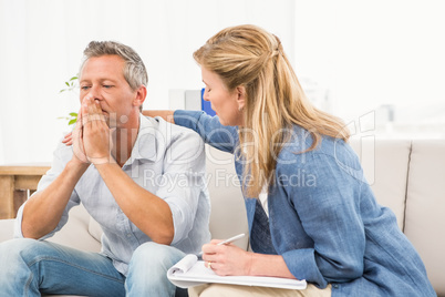 Concerned therapist comforting male patient