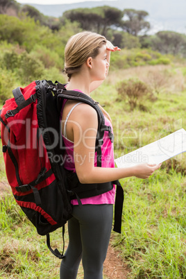 Blonde hiker with map searching for path