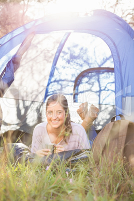 Smiling brunette camper lying in tent
