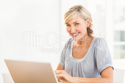 Smiling businesswoman working on a laptop