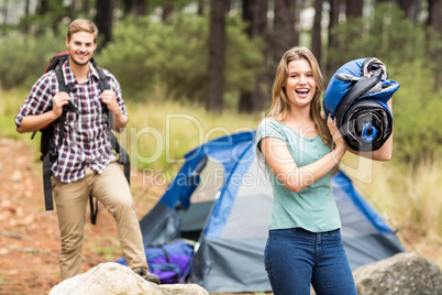 Portrait of a young pretty hiker holding a sleeping bag