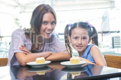 Mother and daughter enjoying cakes at cafe terrace