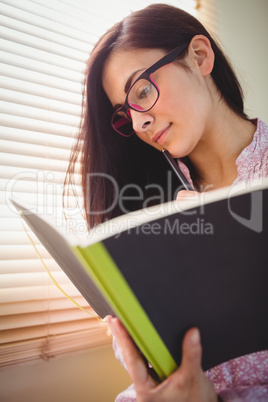 Pretty brunette studying beside window