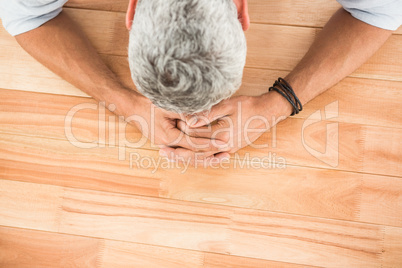 Overworked casual businessman leaning on wooden desk