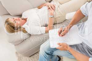 Unhappy woman lying on couch and talking to therapist