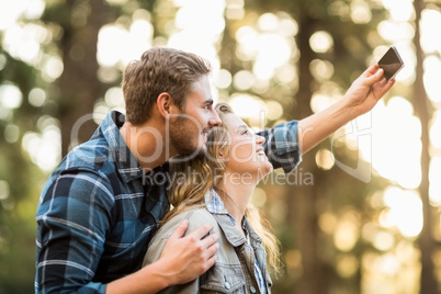 Happy smiling couple embracing and taking selfies