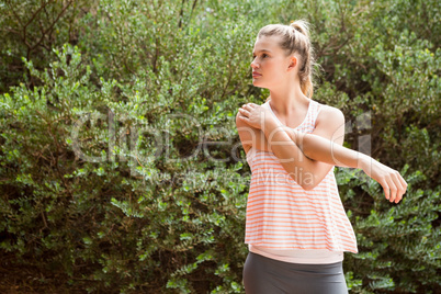 Focused blonde athlete stretching arms