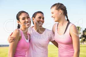 Smiling woman and friends wearing pink for breast cancer