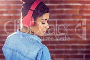 Pretty young woman with headphones looking back