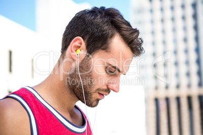 Serious handsome athlete listening to music