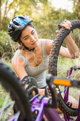 Athletic brunette checking her mountain bike
