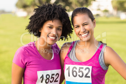 Two smiling runners supporting breast cancer marathon