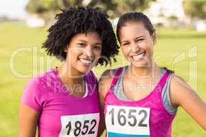 Two smiling runners supporting breast cancer marathon