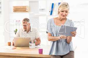 Smiling businesswoman scrolling on a tablet