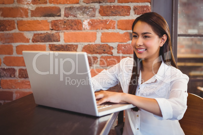 Businesswoman having coffee and working on laptop