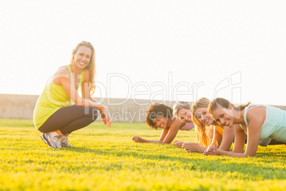 Smiling sporty women planking during fitness class
