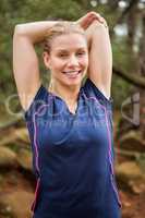 Smiling athletic blonde stretching arms