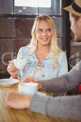 Smiling blonde having coffee with friend