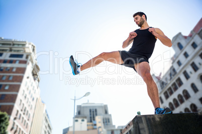 Handsome athlete kicking in the air
