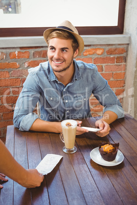 Waitress showing bill to handsome hipster