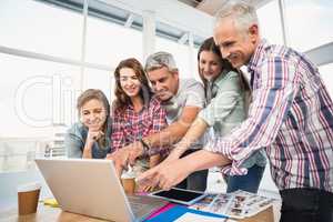 Casual business team having a meeting using laptop