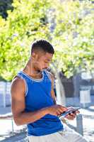 Smiling athletic man using tablet computer