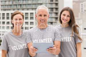 Smiling volunteers with tablet