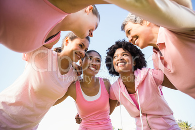 Women wearing pink for breast cancer with arms around