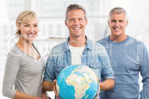 Smiling businessman holding terrestrial globe