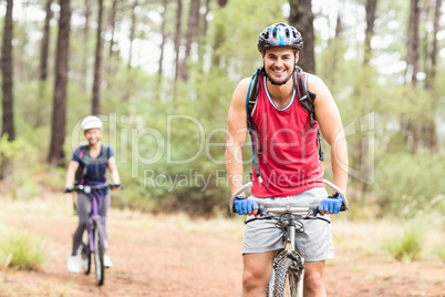 Happy young biker couple looking at camera