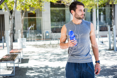 Handsome runner holding a water bottle