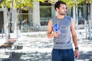 Handsome runner holding a water bottle