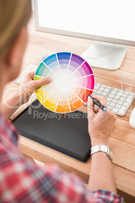 Casual designer working with digitizer and colour chart