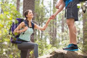 Happy hikers climbing on rock