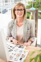 Smiling casual designer working at her desk