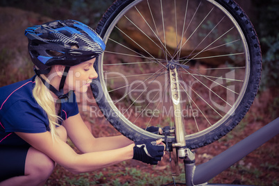 Athletic blonde checking her mountain bike