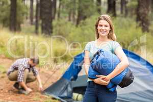 Portrait of a young pretty hiker holding a sleeping bag
