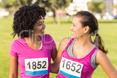 Two smiling runners supporting breast cancer marathon