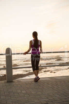 Rear view of fit woman standing at railing