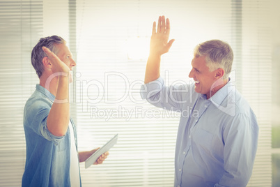 Smiling business colleagues giving high-five