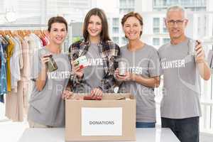 Smiling volunteers showing donations