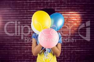 Young woman hiding behind balloons