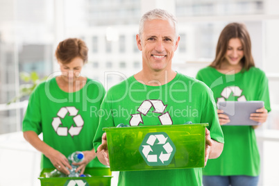 Smiling eco-minded man holding recycling box