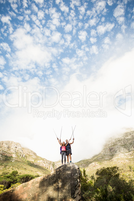 Young happy joggers standing on rock cheering