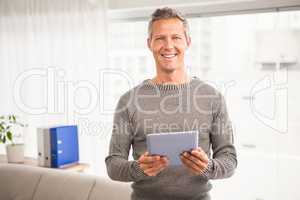 Smiling casual businessman with tablet