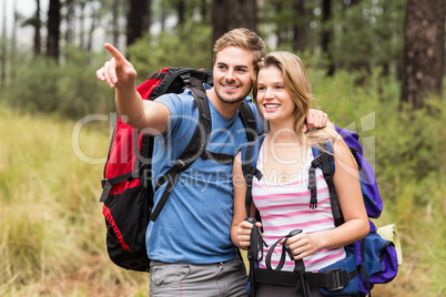 Young happy hiker couple pointing